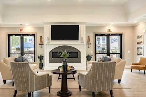 A living room with a fireplace and a television mounted above it.