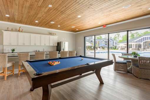 A pool table in a room with a view of the outside.