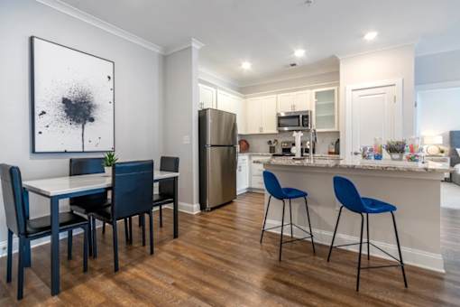 A modern kitchen with a dining table and chairs.