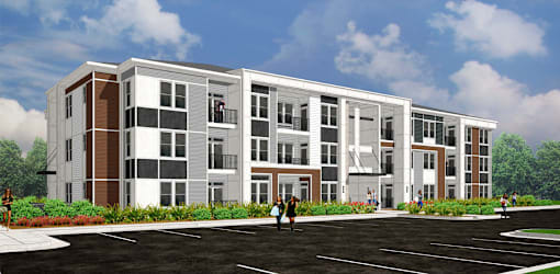 A modern apartment building with a parking lot in front.