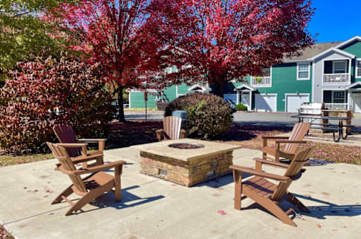 Two chairs and a table are in the foreground of a sunny patio.