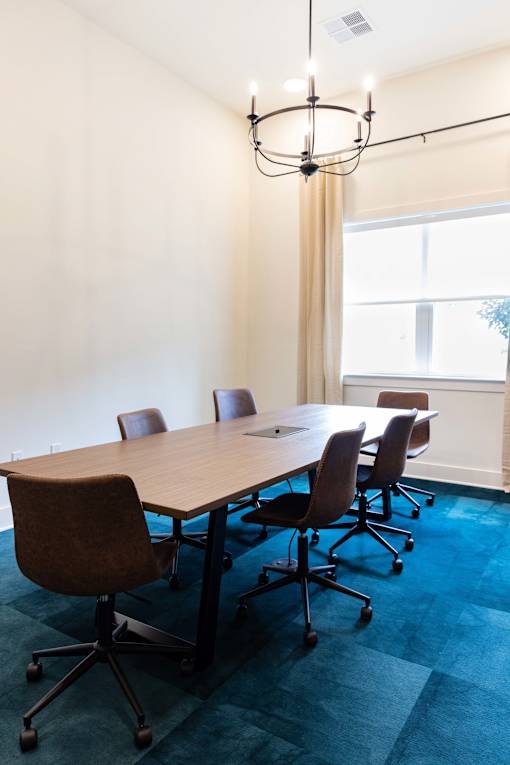 A conference room with a long table and chairs.