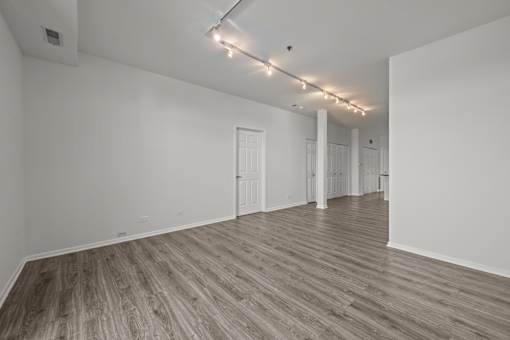 A room with wooden flooring and white walls.