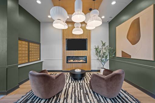 A modern living room with a fireplace and two armchairs.