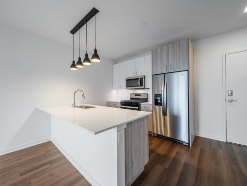 a kitchen with an island and stainless steel refrigerator