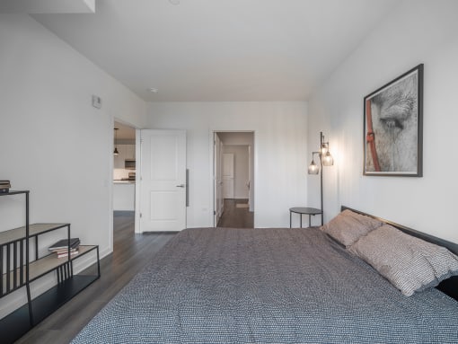a bedroom with a large bed and a painting on the wall