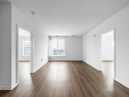 an empty living room with white walls and wood floors