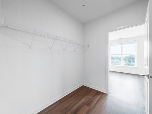 an empty room with white walls and a window