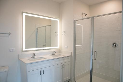 a bathroom with two sinks and a shower