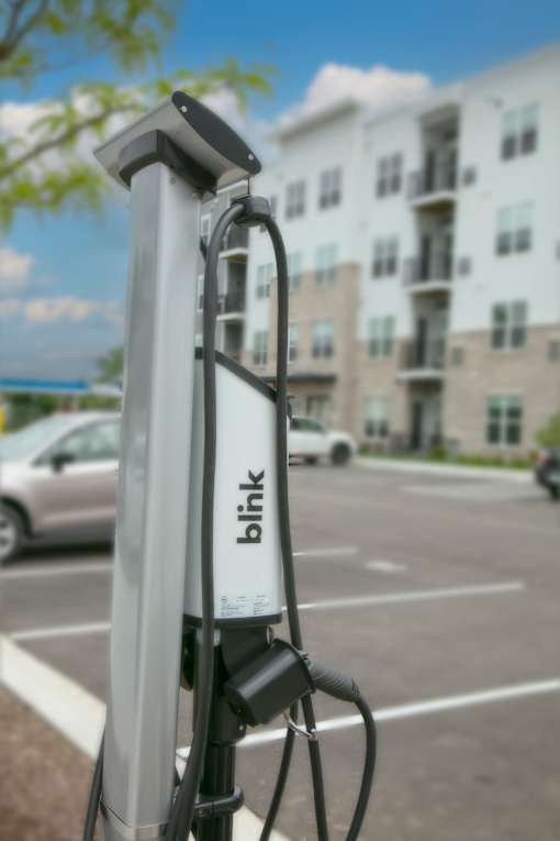 EV charging station in a parking lot in front of an apartment building