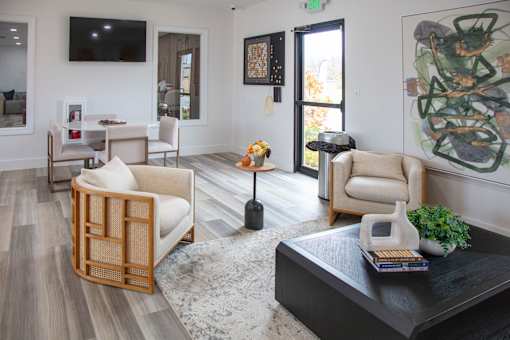 A living room with a black coffee table and a large painting on the wall at Evergreen Luxury Apartments, Merrillville, IN