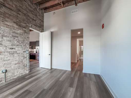 A room with a wooden floor and a brick wall.