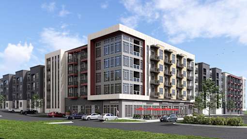 A modern apartment building with a parking lot in front.