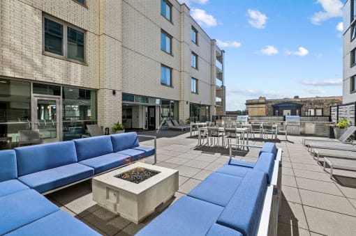 a seating area with couches and chairs on a patio with tables and chairs in the background at Lakeview 3200 Apartments, Chicago, 60657