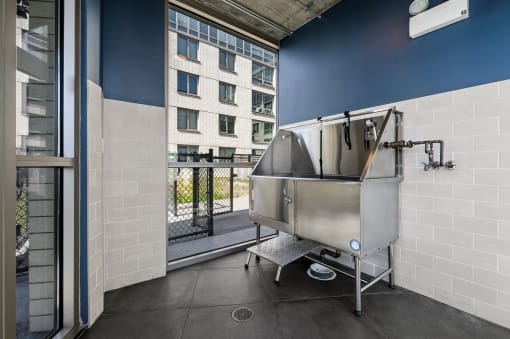 a large stainless steel tub sits in the corner of a room with a balcony in the background at Lakeview 3200 Apartments, Illinois, 60657