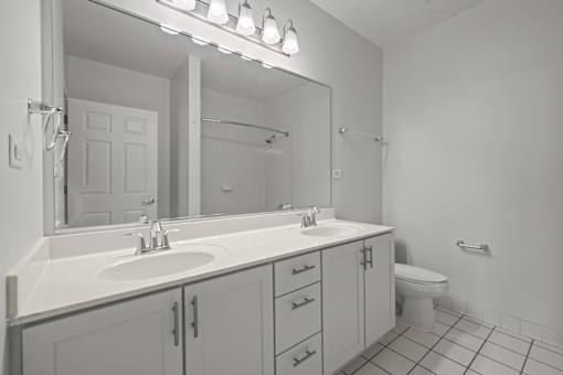 A bathroom with a sink, mirror, and toilet.
