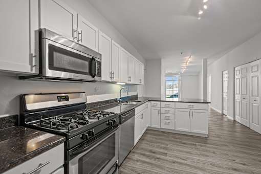 A modern kitchen with a stove, microwave, and oven.