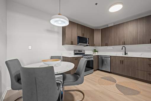 A modern kitchen with a dining table and chairs.