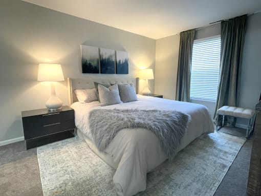a bedroom with a large bed and a window at Evergreen Luxury Apartments, Merrillville
