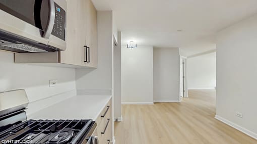 A kitchen with a stove, microwave, and oven.