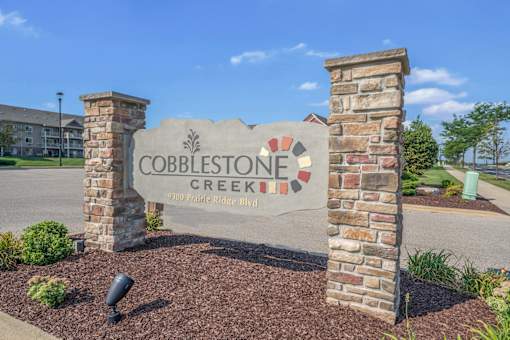 Cobblestone creek sign in front of a building.