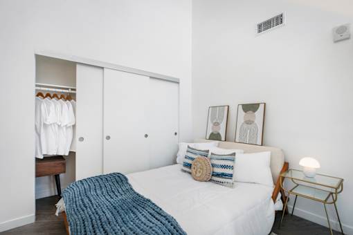 A bedroom with a bed, a nightstand, and a wardrobe.