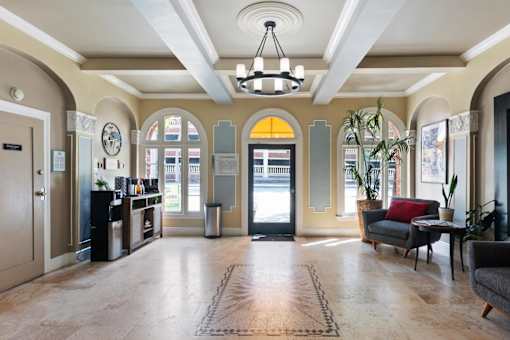 A large, open leasing office with a couch, chairs, and a coffee table.