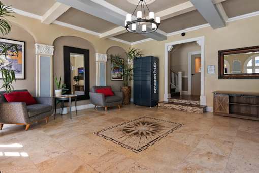 The leasing office at Brookmore Apartments Pasadena with a rug in the middle and a chandelier hanging from the ceiling.