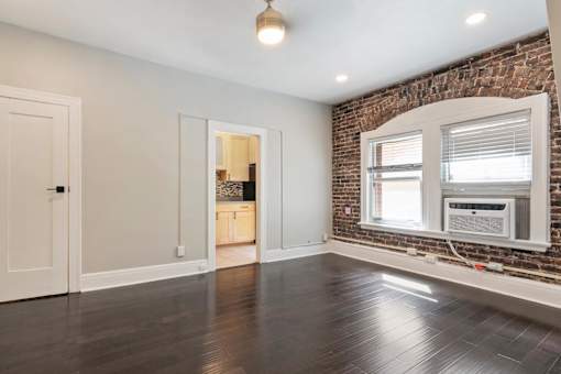 A room with a brick wall and a window.