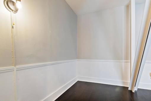 A white wall with a lamp on the left side in a studio apartment in Pasadena, CA at Brookmore.