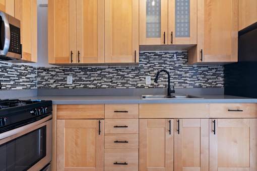 A kitchen with wooden cabinets and a black stove top oven.