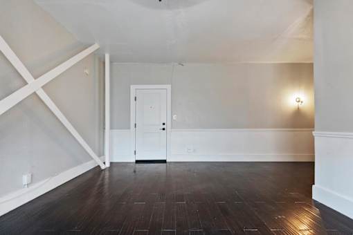 A studio apartment with a white door and a white wall with a cross design on the wall in Pasadena, CA.