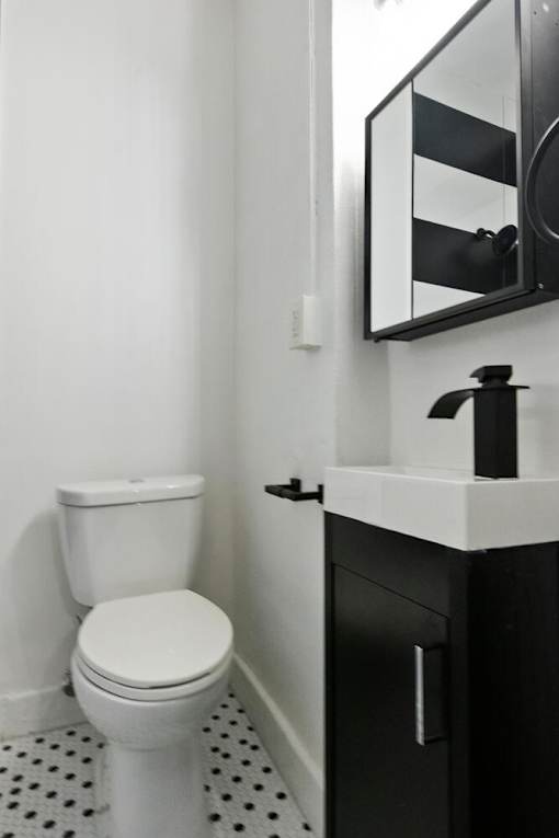 A white toilet sits next to a sink in a bathroom.
