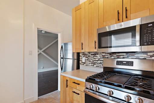 A studio apartment kitchen with a stove, microwave, and oven.