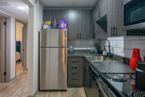 Nashville Apartments - The Canvas - Modern Kitchen with Soft-Close Wood-Inspired Cabinets, Stainless-Steel Appliances, and Hardwood-Inspired Flooring