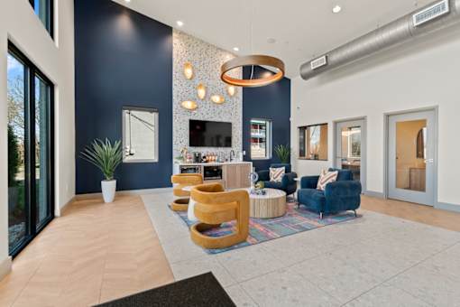 The Canvas Apartments Nashville leasing office with coffee bar and seating area with blue and gold chairs.