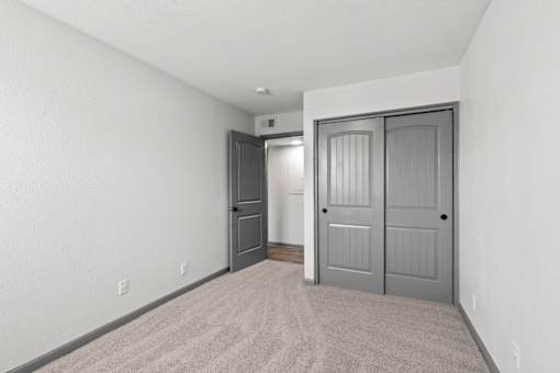The Canvas Apartments Nashville bedroom with a grey carpet and a grey door.