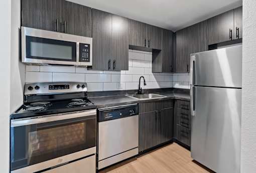 The Canvas one and two bedroom apartments Nashville modern kitchen with stainless steel appliances and wooden cabinets.