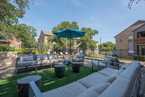 Fusion 35 patio with a white couch, a blue umbrella, and grass.