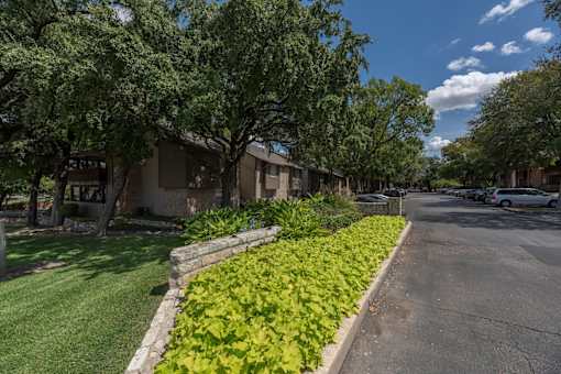 A street view of Fusion 35 Apartments with parked cars.