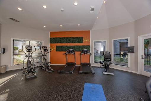 Fusion 35 gym with orange wall and exercise equipment.