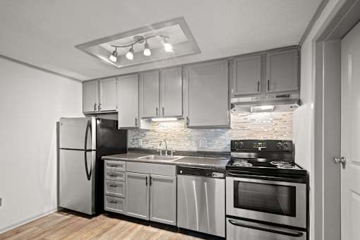 Retreat at Indian Lake Hendersonville TN apartments modern kitchen with stainless steel appliances and wooden flooring.