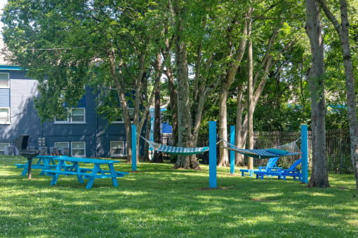 Nashville TN Apartments - The Canvas - Outdoor Hammock Lounge with Two Hammocks, Outdoor Grill Station, and Picnic Seating Surrounded By Lush Landscaping