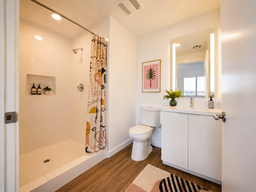 A bathroom with a toilet, sink, and shower.