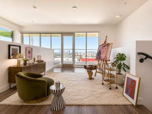 A loft room with a green chair and a painting on the easel.