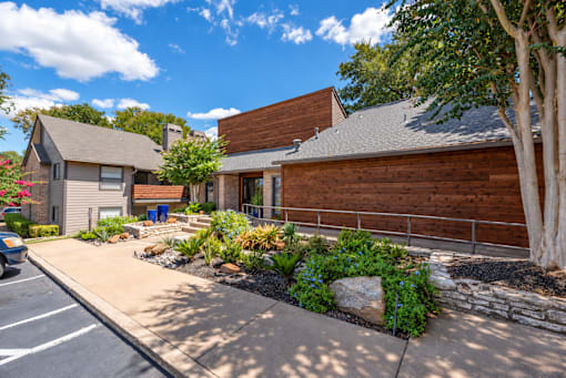 Fusion 35 modern leasing office with a wooden exterior and a stone pathway leading to the front door.