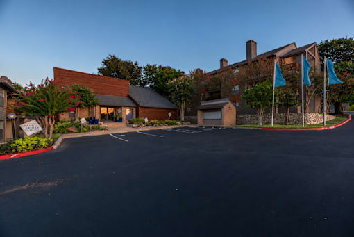 Fusion 35 parking lot in front of a building with blue flags to the right.