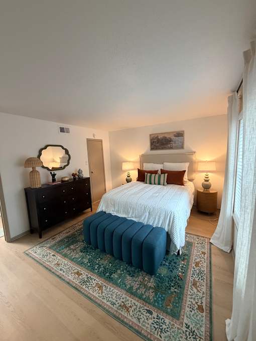 Fusion Crossroads bedroom with a bed, dresser, and a rug.