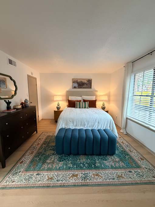 Fusion Crossroads bedroom with a bed, dresser, and mirror.