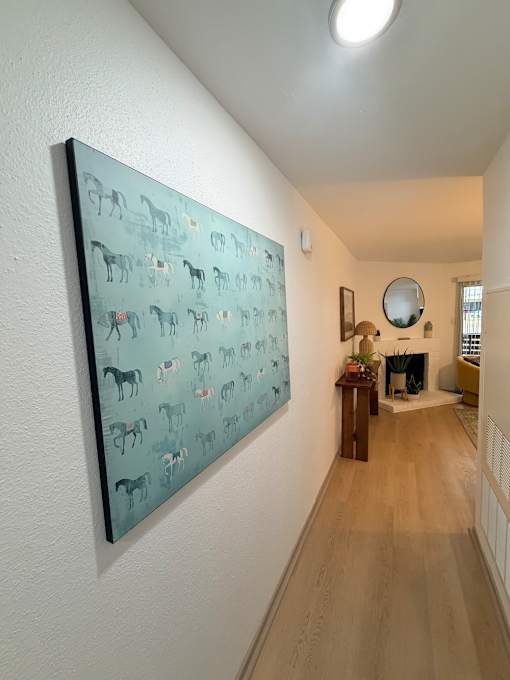 Fusion Crossroads hallway with a painting of animals on the wall looking into the living room.